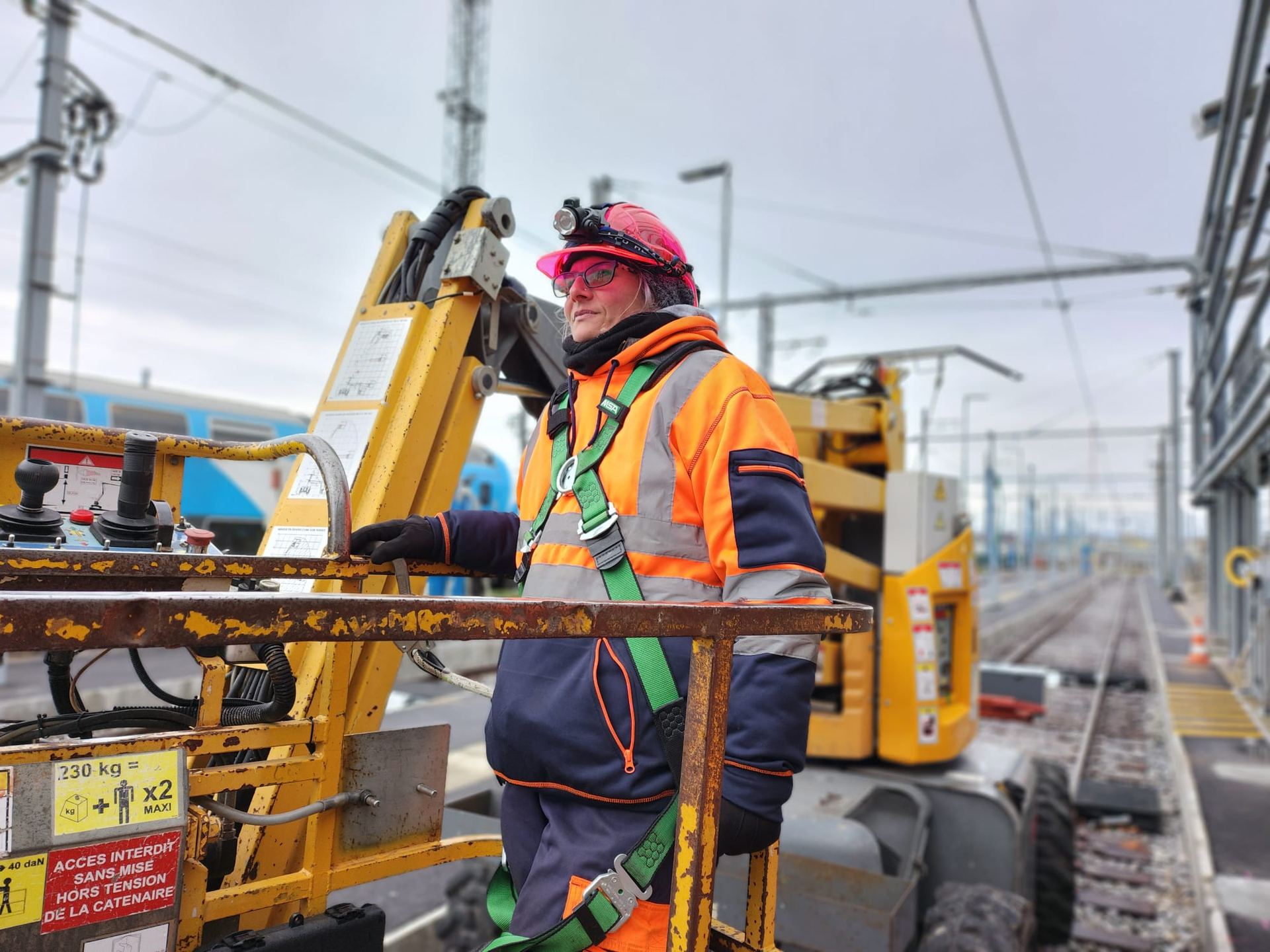 Conductrice qualifiée sur une nacelle rail-route, équipée de ses EPI